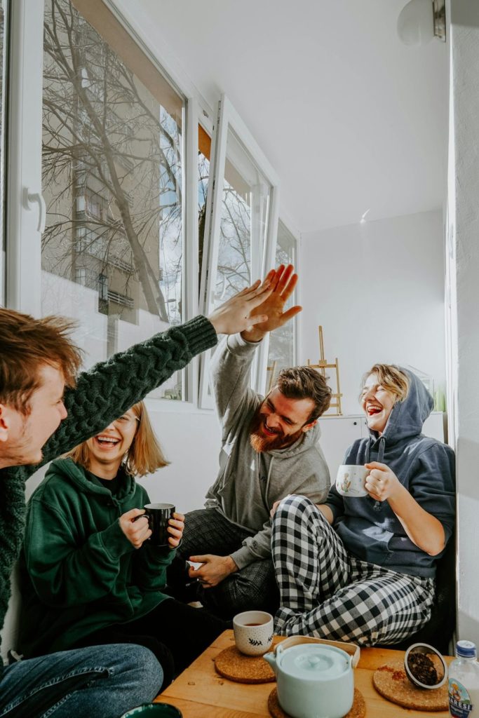 Friends high-fiving over coffee