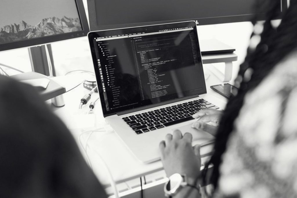 A developer coding on a laptop